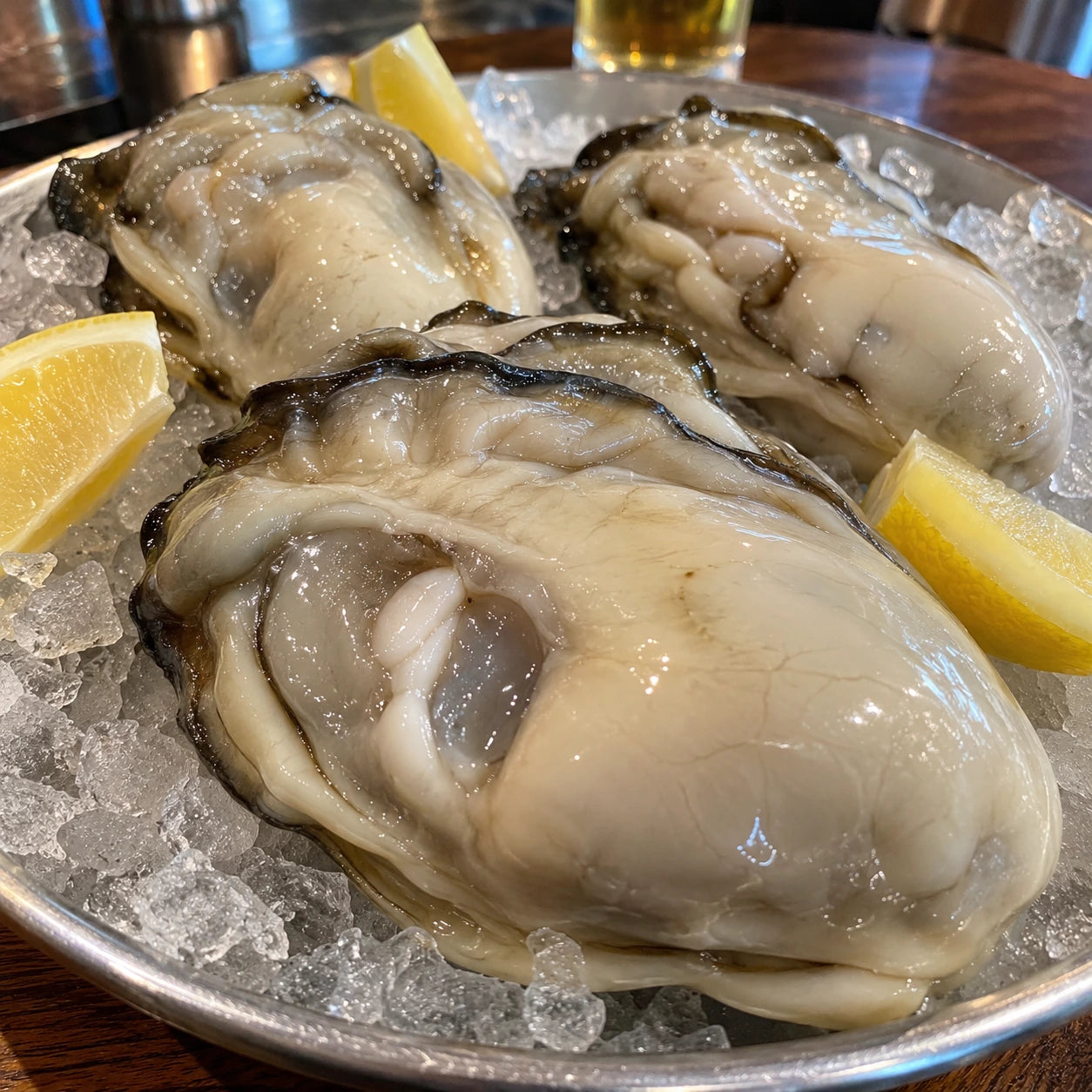 Large oyster meats arranged on crushed ice with lemon.